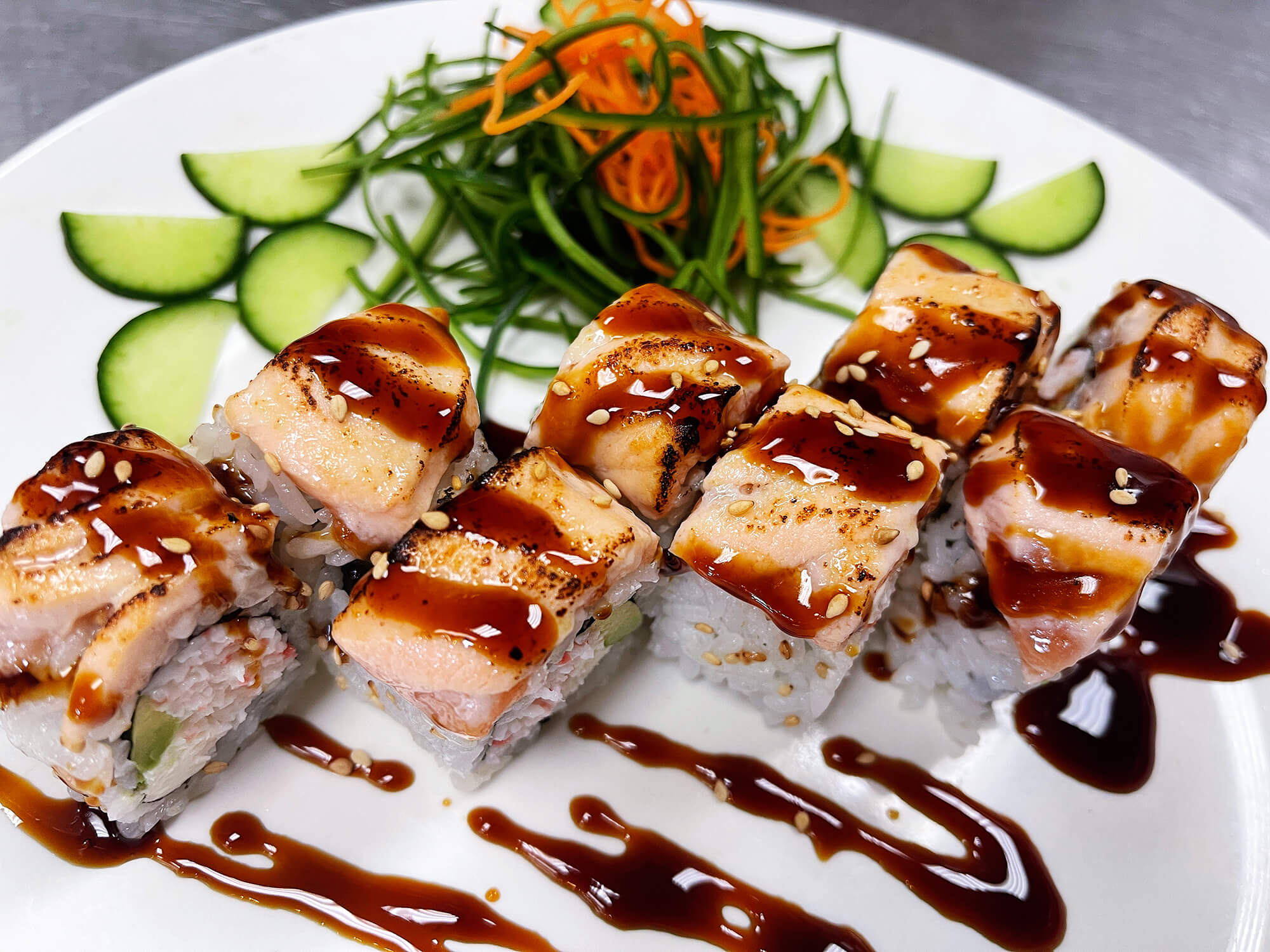 Aloha-Hawaiian-BBQ-&-Sushi-Asian-Fusion-restaurant-Seared-Salmon-Sushi-Roll-Baldwin-Park Sushi roll with seared salmon, drizzled with sauce at Aloha Hawaiian BBQ & Sushi, a Asian Fusion restaurant in Baldwin Park