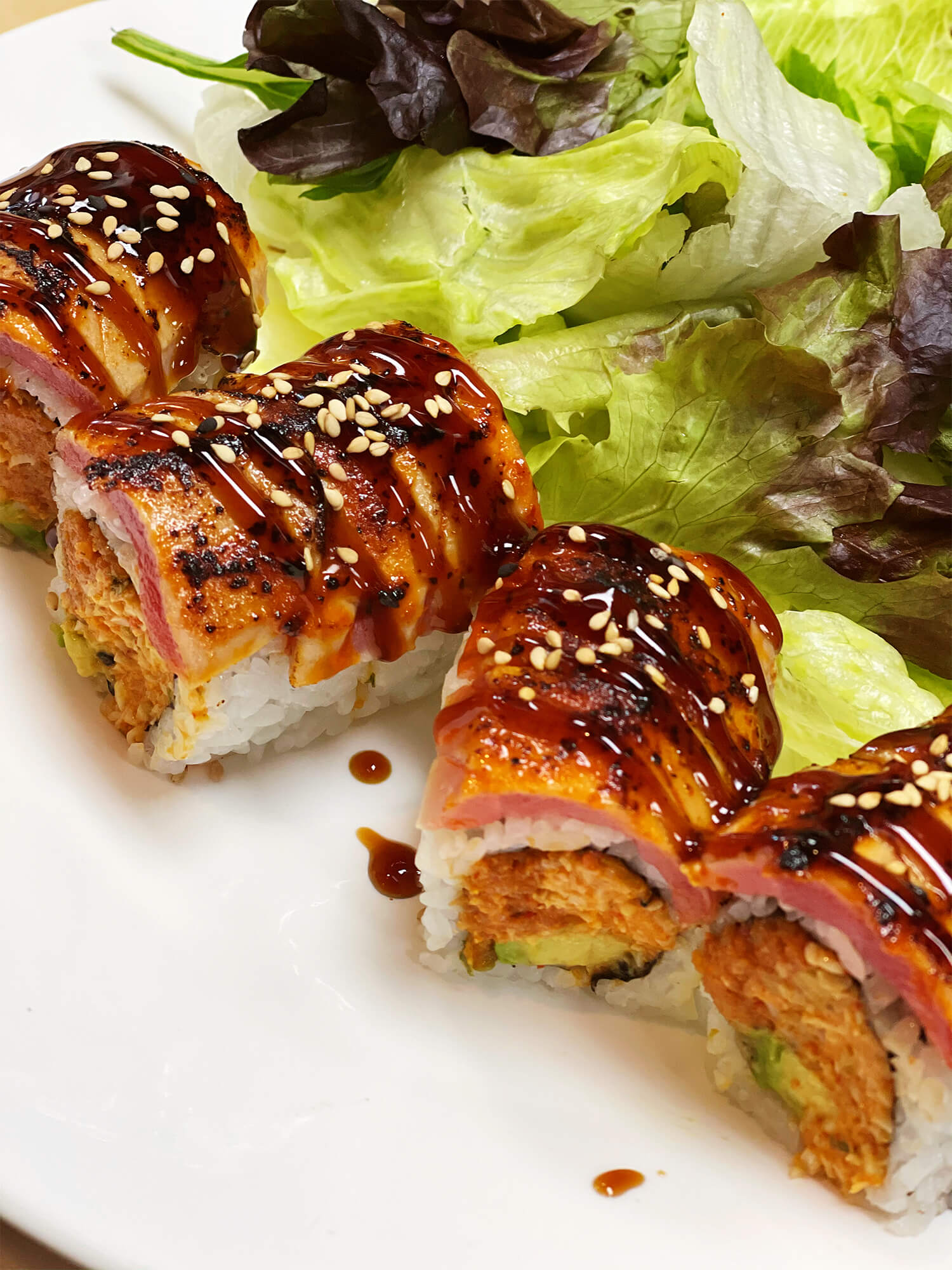 Aloha-Hawaiian-BBQ-&-Sushi-Asian-Fusion-restaurant-Seared-Salmon-Sushi-Roll-Baldwin-Park Sushi roll with seared salmon, sesame seeds, and sauce at Aloha Hawaiian BBQ & Sushi, a Asian Fusion restaurant in Baldwin Park